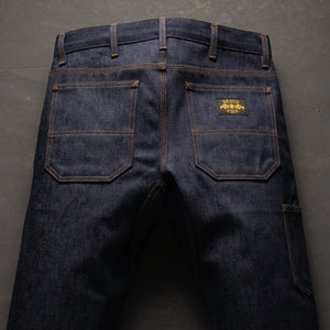 Dark blue jeans with a brand logo on the back pocket against a gray background
